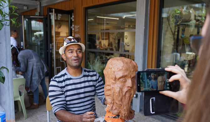 Russel YAHIYA photo du profil, représentant l'artiste en pleine création d'une oeuvre en terre